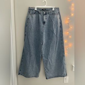 Medium-wash, wide-leg denim jeans.
